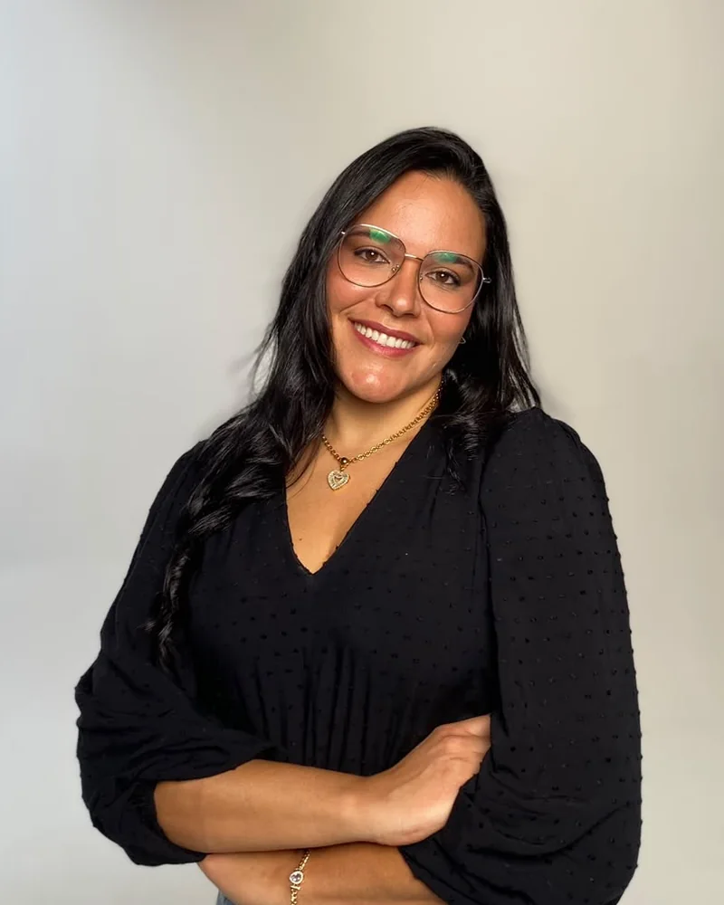 Dra. Manuella Vidal sorrindo, de braços cruzados